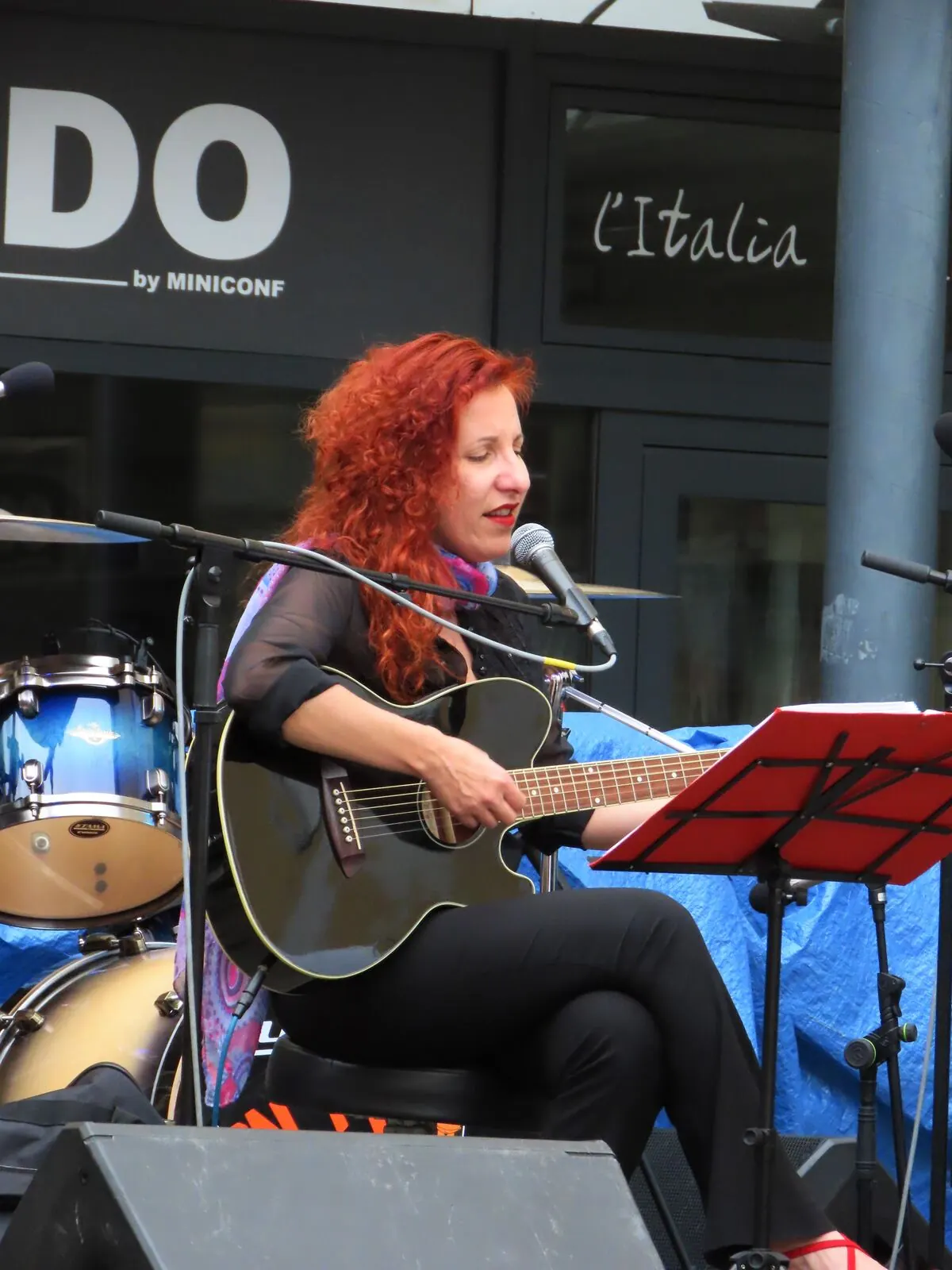 Eine Sängerin mit Gitarre auf einer Bühne auf dem Platz