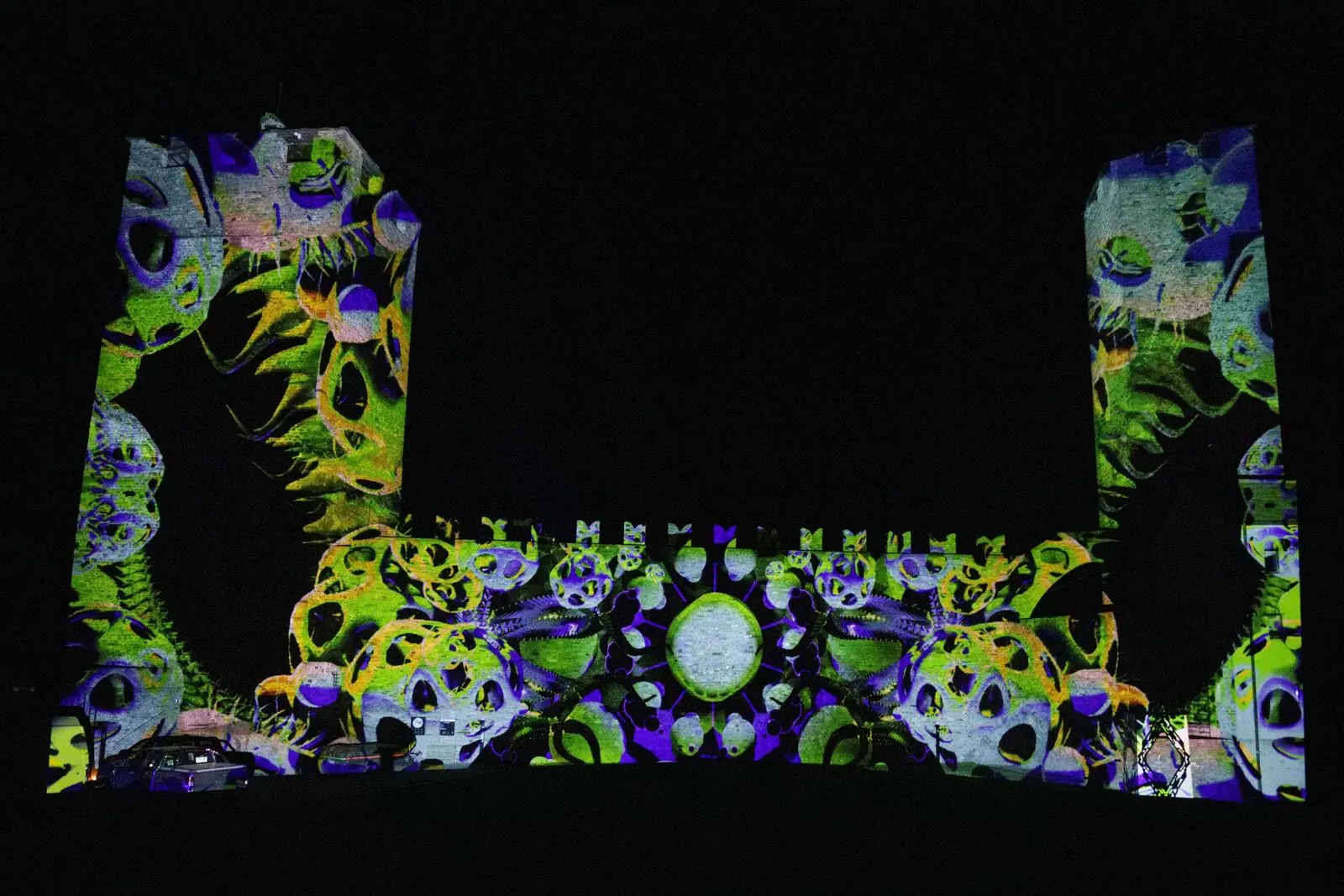 Grün-violettes Videomapping auf den Mauern von Castelgrande während der Notte Bianca